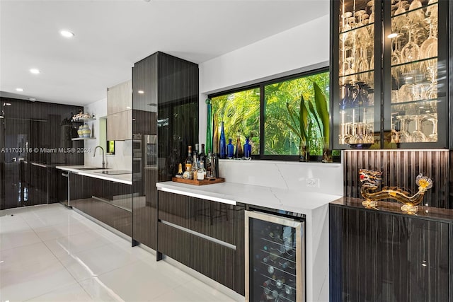 bar featuring light stone countertops, light tile patterned floors, sink, and beverage cooler