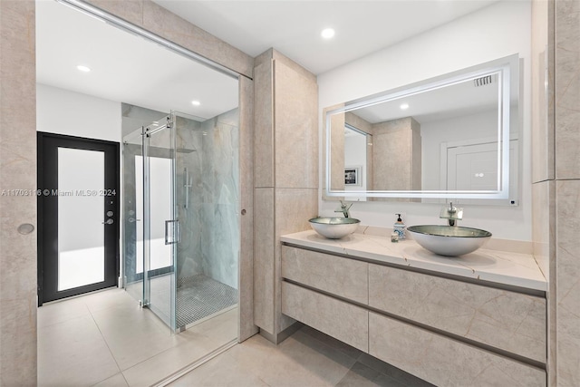 bathroom featuring tile patterned flooring, vanity, and a shower with shower door