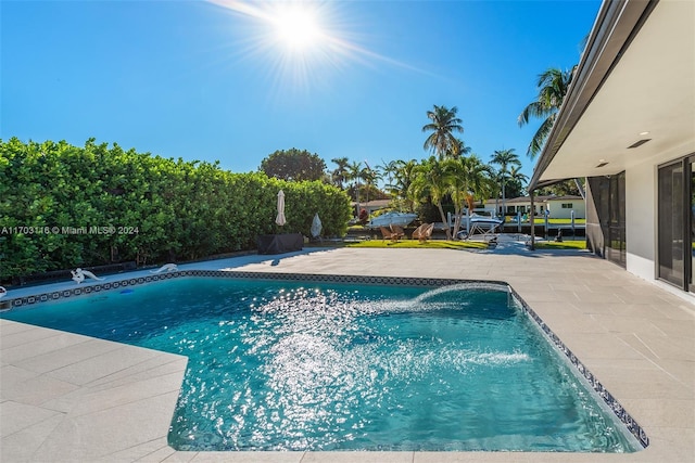 view of swimming pool featuring pool water feature and a patio area