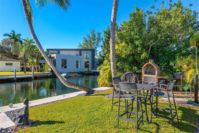 view of yard featuring an outdoor stone fireplace and a water view