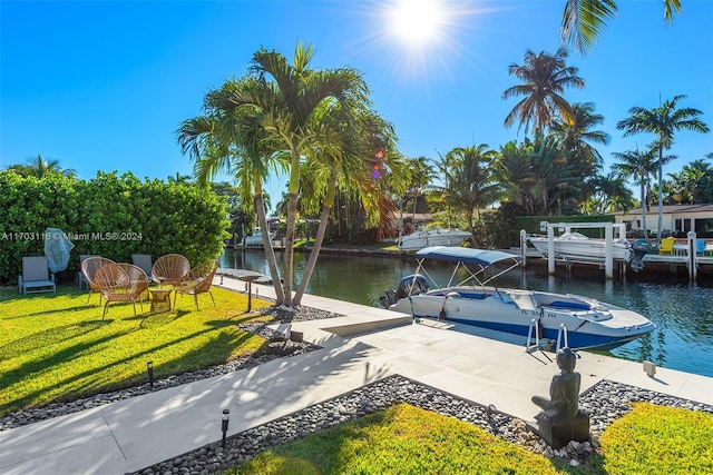 view of dock with a yard and a water view