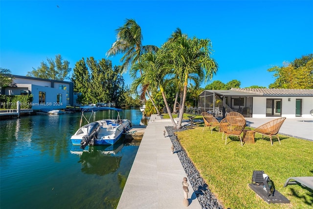 view of dock with a water view, a lanai, and a lawn