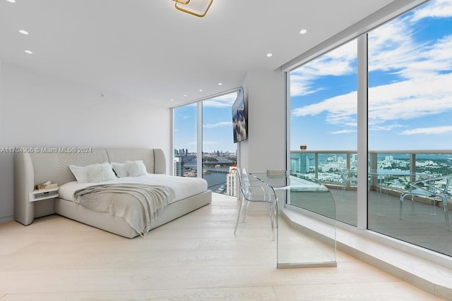 bedroom featuring floor to ceiling windows, access to exterior, and wood-type flooring