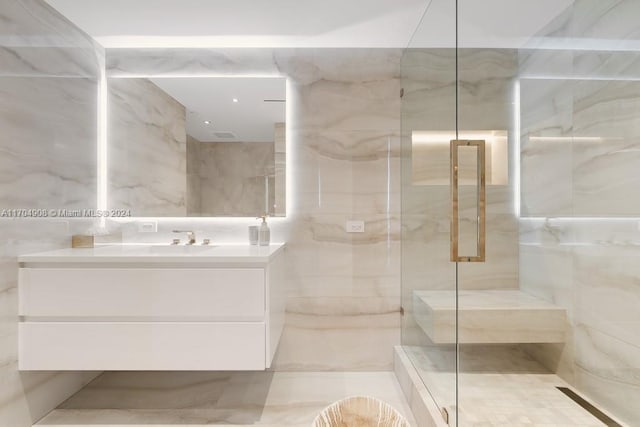 bathroom featuring an enclosed shower, vanity, and tile walls