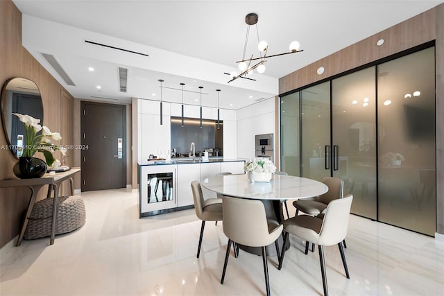 dining room featuring sink, wooden walls, and a chandelier