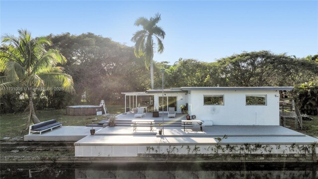 view of dock with a deck with water view and a patio