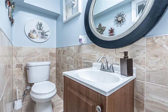 bathroom featuring vanity, toilet, and tile walls