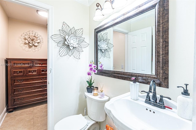 bathroom featuring toilet, tile patterned floors, ornamental molding, and sink