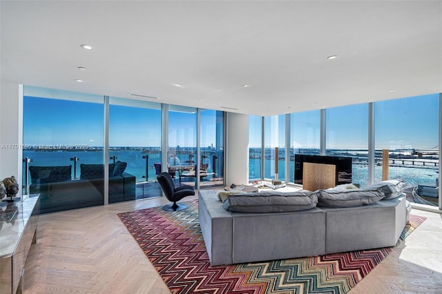 living room with a water view, parquet flooring, and expansive windows