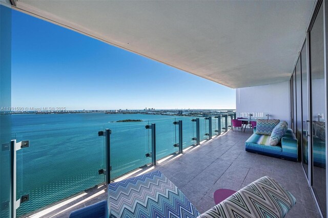 dining space with expansive windows, a water view, and light parquet floors