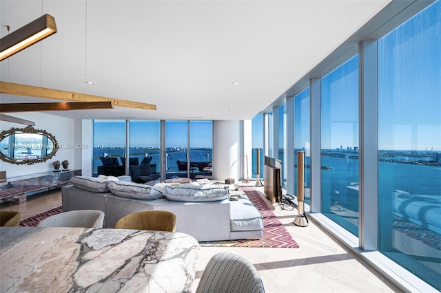 living room featuring a water view and a wall of windows