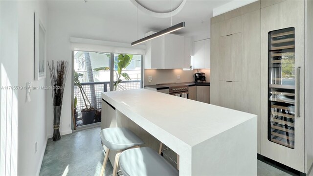 kitchen featuring a kitchen breakfast bar, wine cooler, and white cabinets