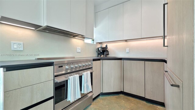 kitchen featuring extractor fan, sink, white cabinetry, and electric stove