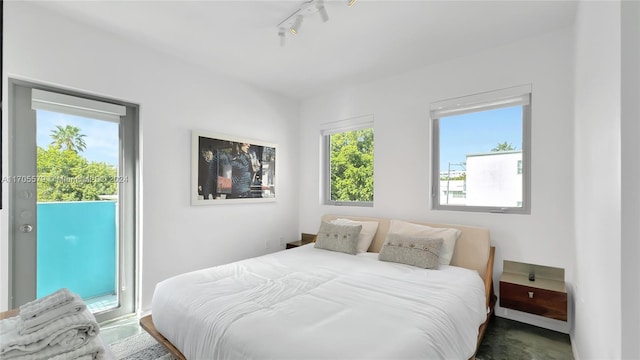 bedroom featuring rail lighting and access to outside