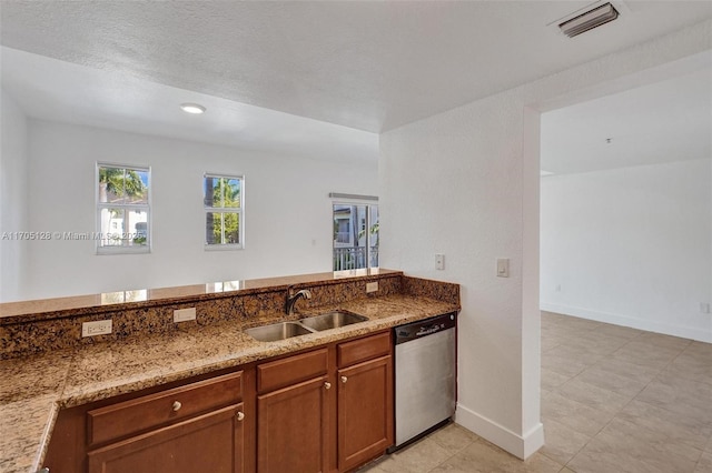 kitchen featuring light stone counters, a sink, visible vents, stainless steel dishwasher, and brown cabinetry