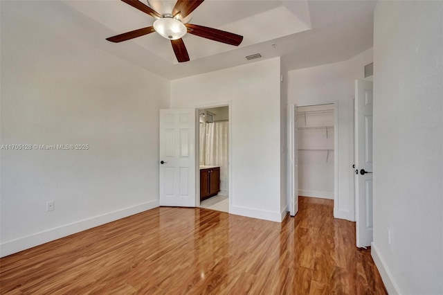 unfurnished bedroom featuring light wood finished floors, baseboards, visible vents, and a closet