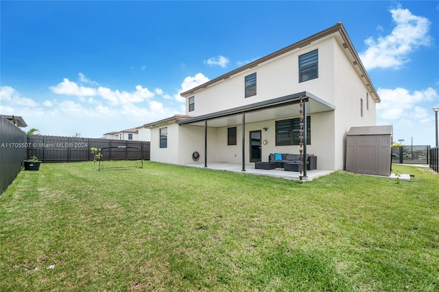 rear view of house featuring a lawn, an outdoor living space, a shed, and a patio