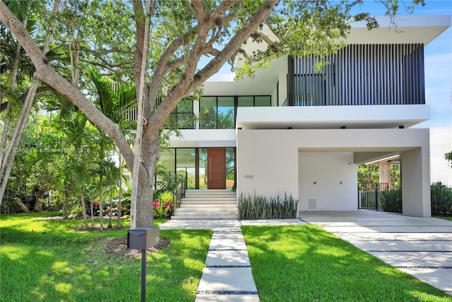 100 Hampton Ln, Key Biscayne, FL 33149 - modern home with stairway, stucco siding, a carport, and a front yard