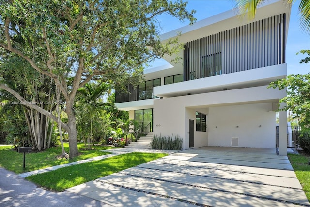 100 Hampton Ln, Key Biscayne, FL 33149 - contemporary house featuring stucco siding, driveway, and a carport