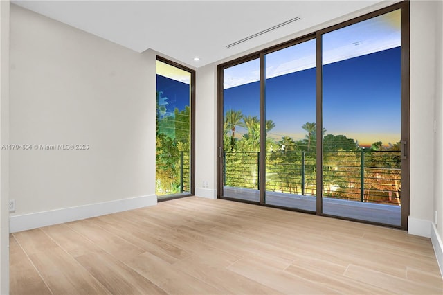 100 Hampton Ln, Key Biscayne, FL 33149 - unfurnished room with baseboards, visible vents, expansive windows, and wood finished floors