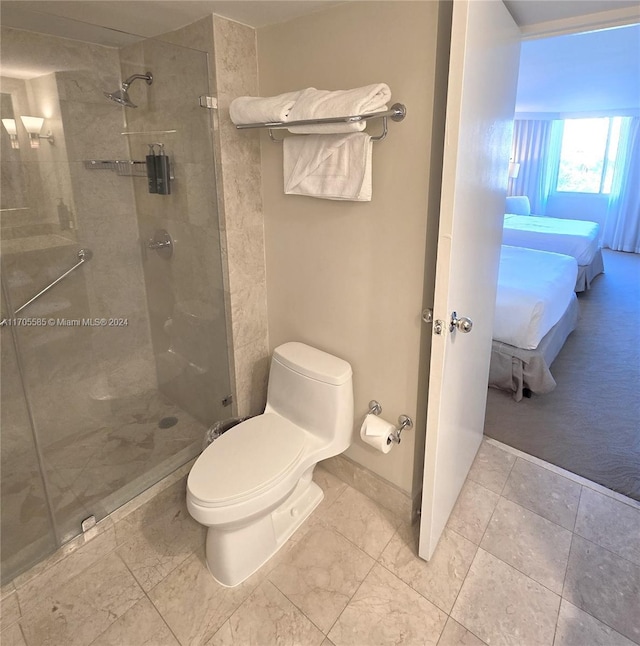 bathroom with toilet and a shower with door