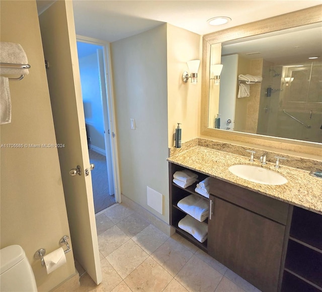 bathroom with tile patterned floors, vanity, toilet, and a shower with shower door