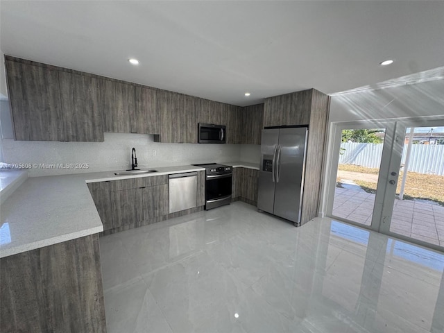 kitchen with stainless steel appliances, dark brown cabinetry, and sink