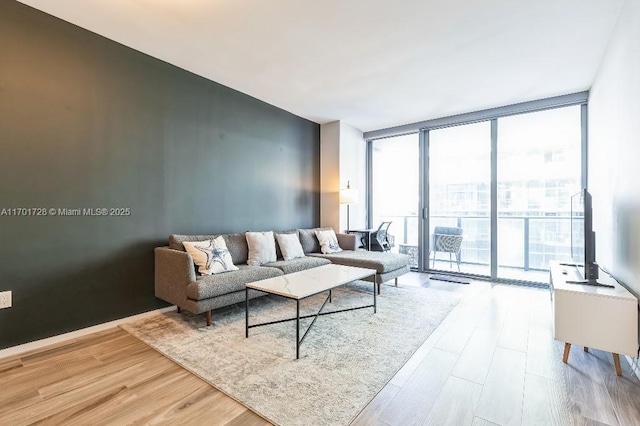 living room featuring a wall of windows and light hardwood / wood-style flooring