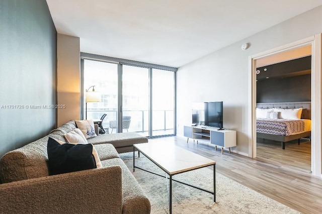 living room with expansive windows and light hardwood / wood-style floors