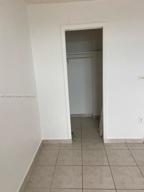 unfurnished bedroom with light tile patterned floors and a closet