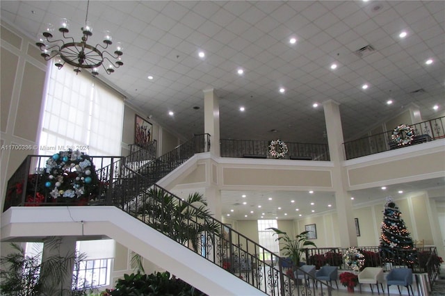 interior space featuring a towering ceiling, a wealth of natural light, and a chandelier