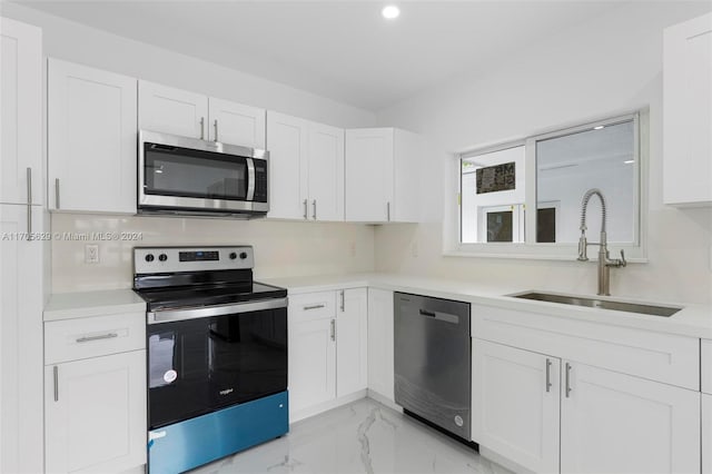 kitchen featuring white cabinets, appliances with stainless steel finishes, tasteful backsplash, and sink