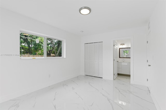 unfurnished bedroom featuring ensuite bathroom and a closet