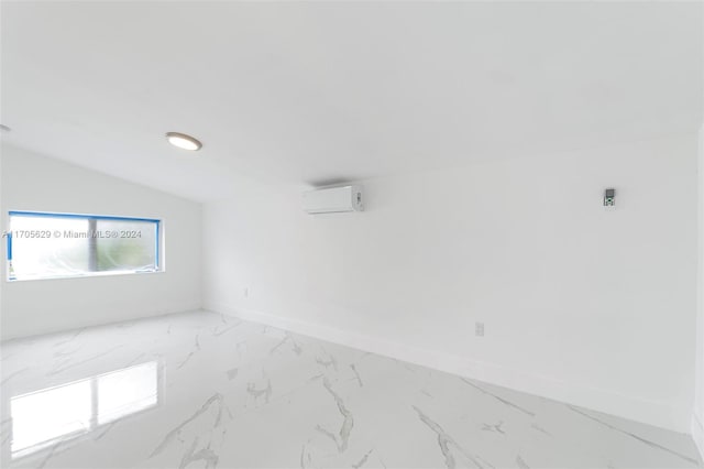 empty room with a wall mounted air conditioner and vaulted ceiling