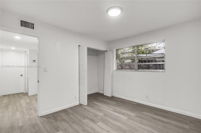 unfurnished bedroom with a closet and light hardwood / wood-style flooring