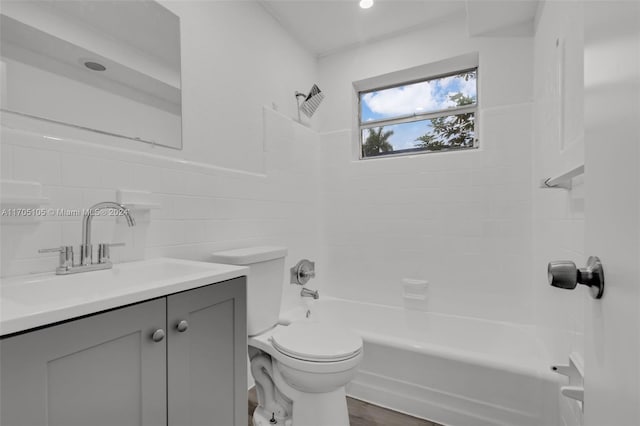 full bathroom with vanity, tiled shower / bath combo, hardwood / wood-style flooring, tile walls, and toilet