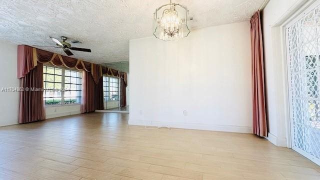 unfurnished room with ceiling fan with notable chandelier, a textured ceiling, and light hardwood / wood-style floors