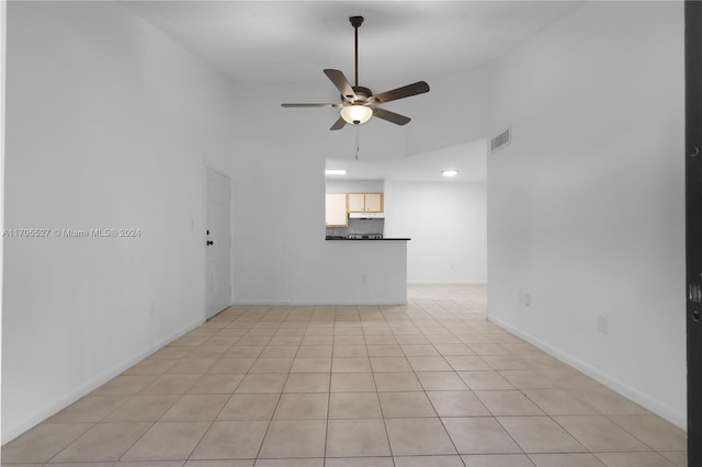 tiled empty room featuring ceiling fan and high vaulted ceiling