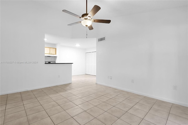 tiled empty room featuring ceiling fan