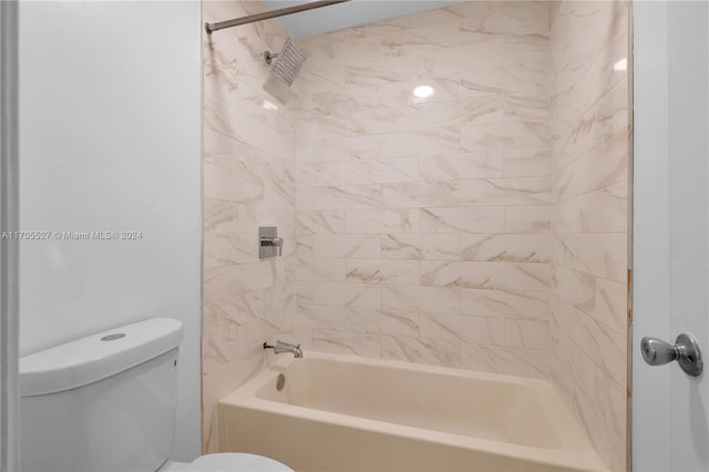 bathroom featuring tiled shower / bath combo and toilet