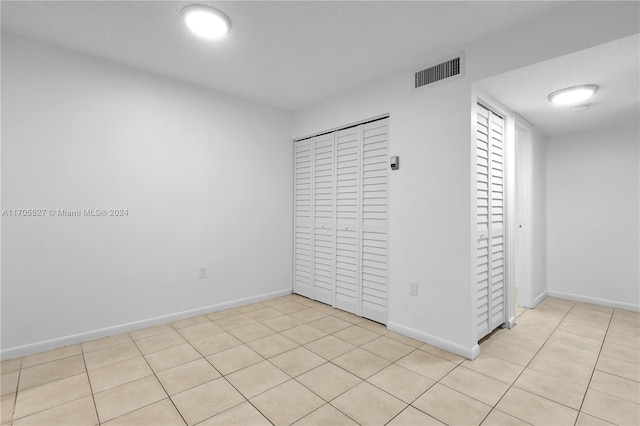 unfurnished bedroom featuring light tile patterned flooring and a closet