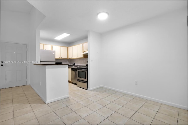 kitchen with stainless steel range with electric stovetop, white refrigerator, light tile patterned floors, tasteful backsplash, and kitchen peninsula