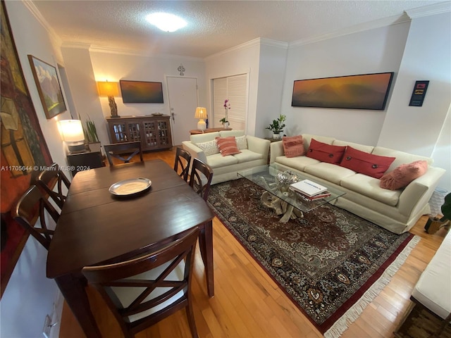 living room with hardwood / wood-style flooring, crown molding, and a textured ceiling