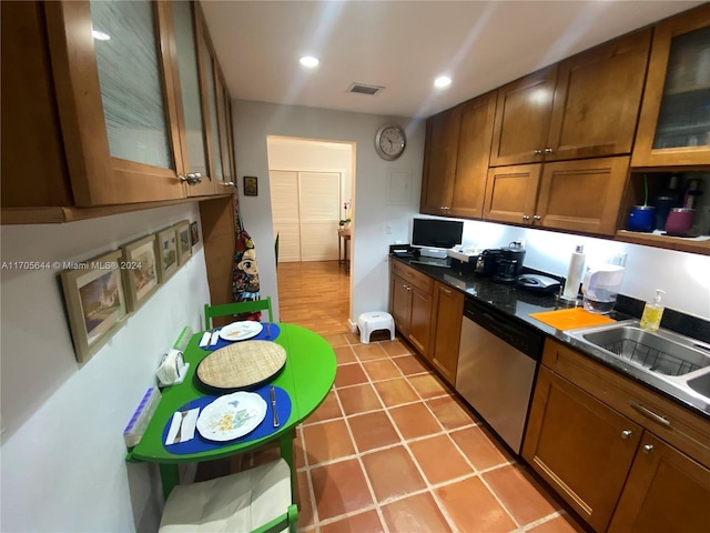 kitchen featuring stainless steel dishwasher, light tile patterned flooring, and sink