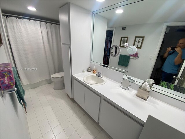 bathroom featuring tile patterned flooring, vanity, and toilet