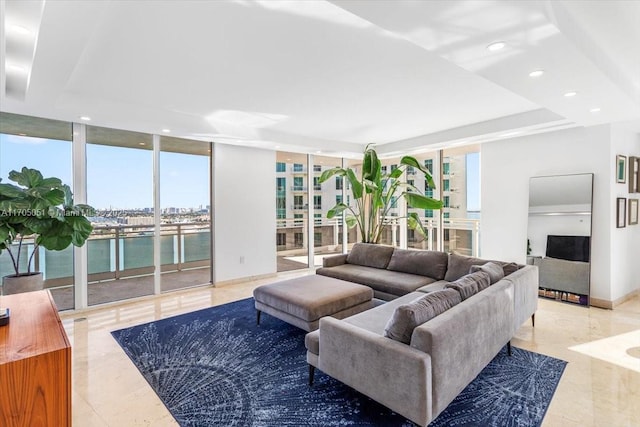 living room with a wall of windows, recessed lighting, a water view, and light tile patterned floors