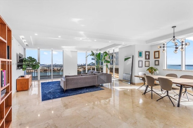 living room featuring a water view, a chandelier, and a wall of windows