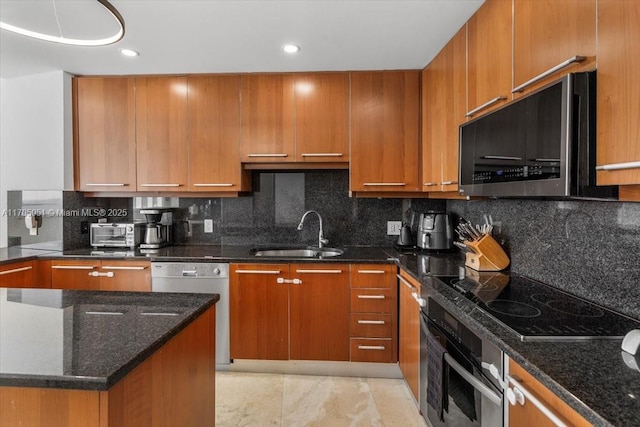 kitchen with wall oven, stainless steel microwave, dark stone countertops, white dishwasher, and a sink