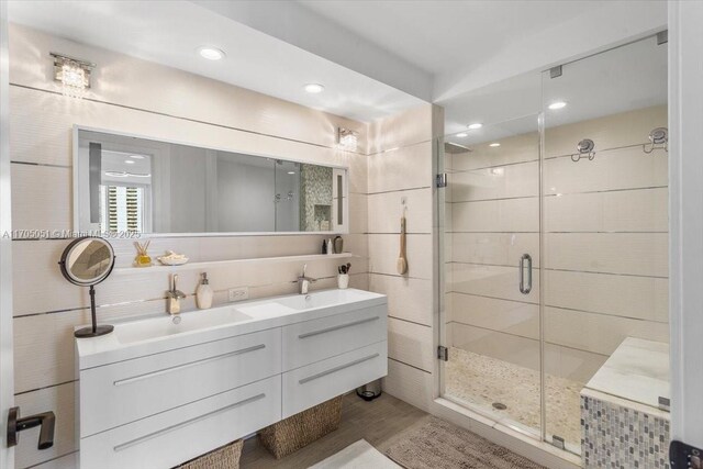 bathroom with hardwood / wood-style floors, vanity, and a shower with door