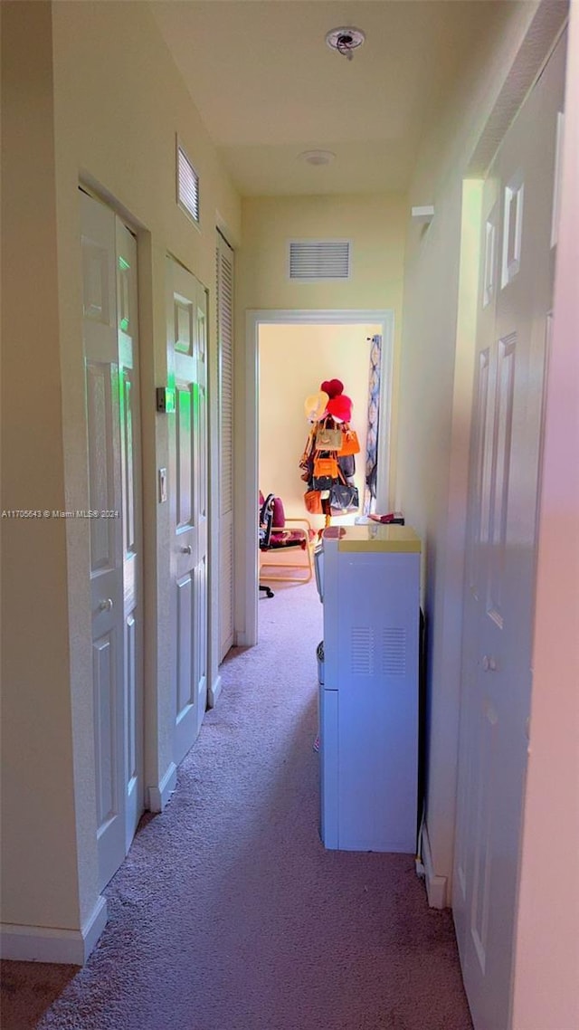 hallway featuring light colored carpet